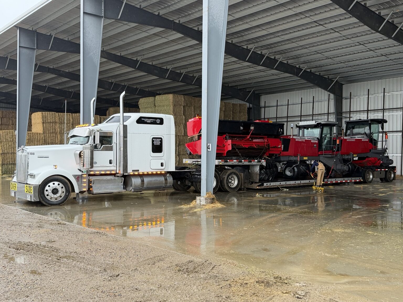 Two Massey Ferguson windrowers being cleaned after transport
